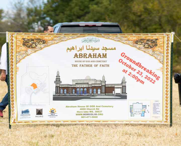 A sign advertising the groundbreaking of Abraham House of God Mosque & Cemetery, with a drawing of a mosque.