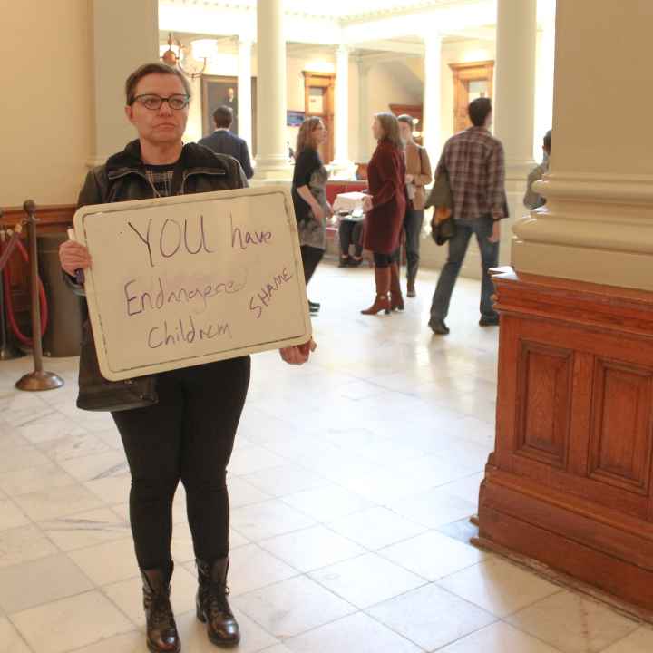 A woman holds a sign outside of the Georgia Senate chambers on March 22, 2023, following the passage of SB 140
